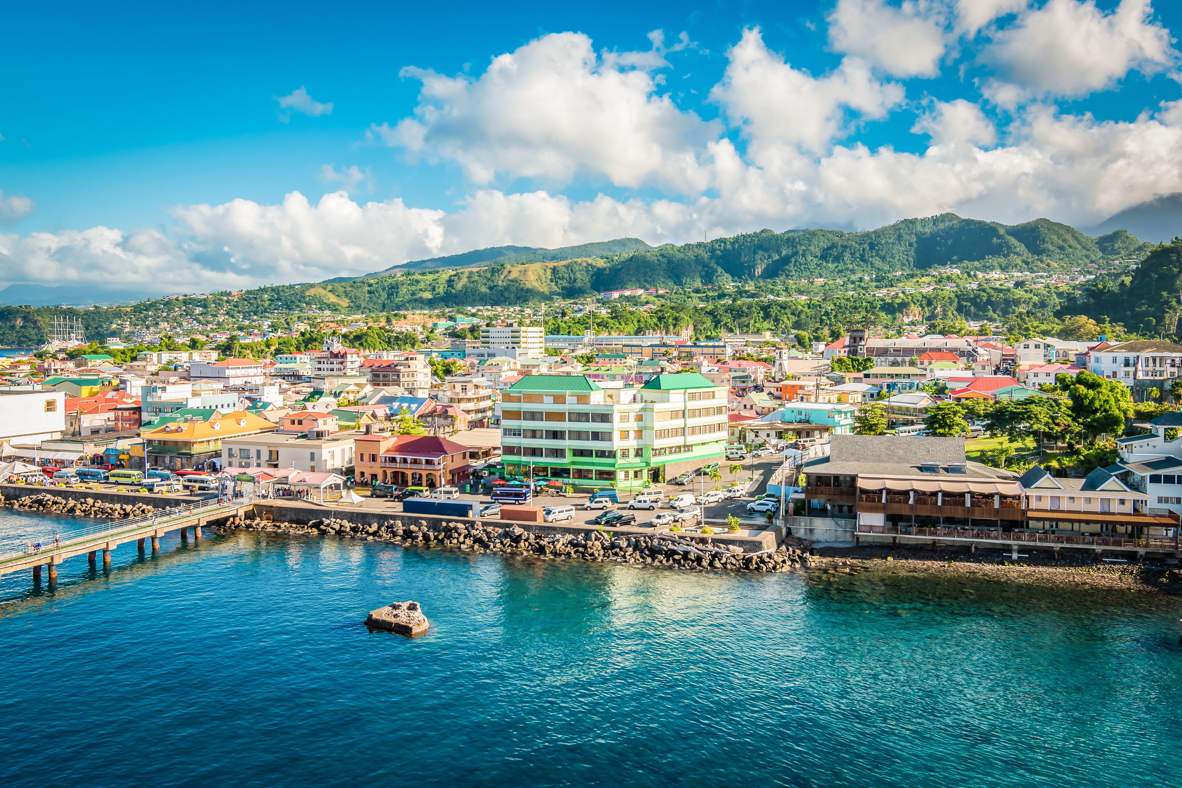 Aerial view of Roseau, Dominica — colorful waterfront buildings beneath green mountains