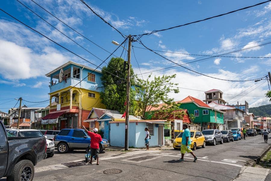 Colorful houses on a Roseau street in Dominica under a bright blue sky